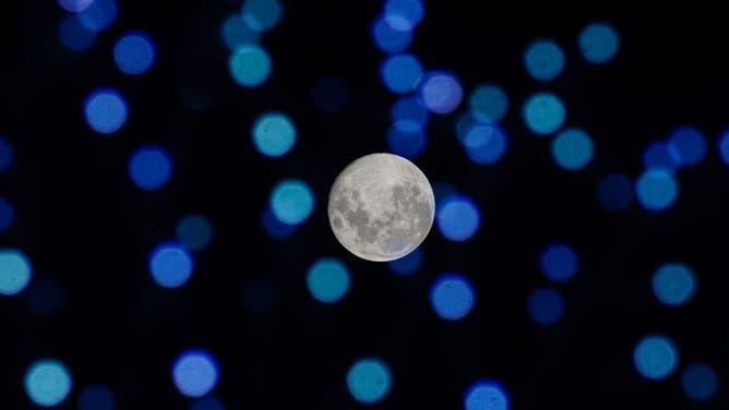 The Beaver moon is seen through Christmas lights from the historic center on November 28, 2023 in San Salvador, El Salvador.