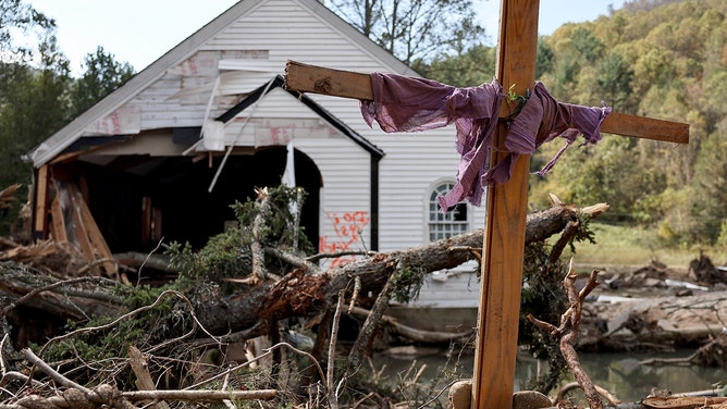 A makeshift cross stands amid fallen trees in front of a destroyed church in the aftermath of Hurricane Helene flooding on October 6, 2024 in Swannanoa, North Carolina.